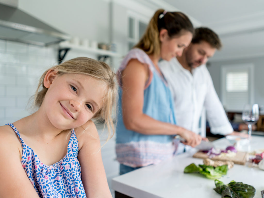 Girl cooking dinner with her family